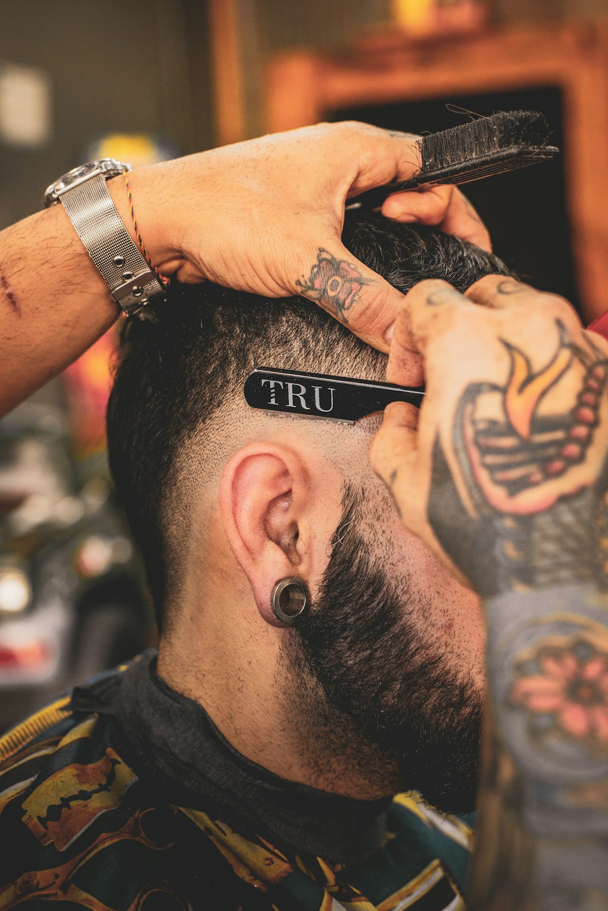 Barber shaping a close fade